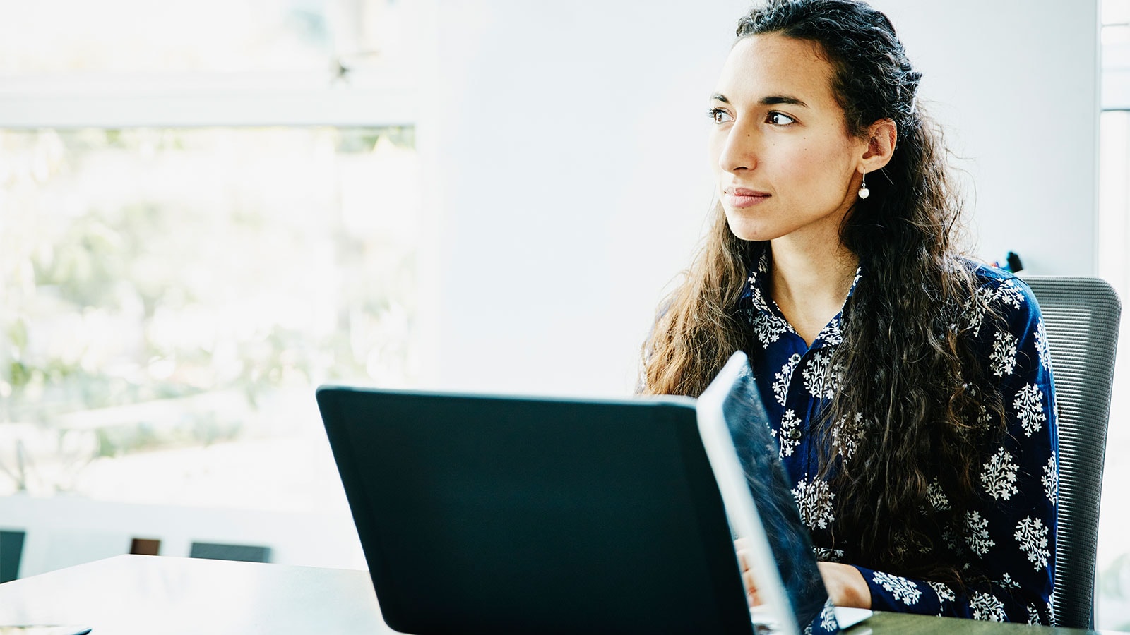 Businesswoman working on laptop in office conference room